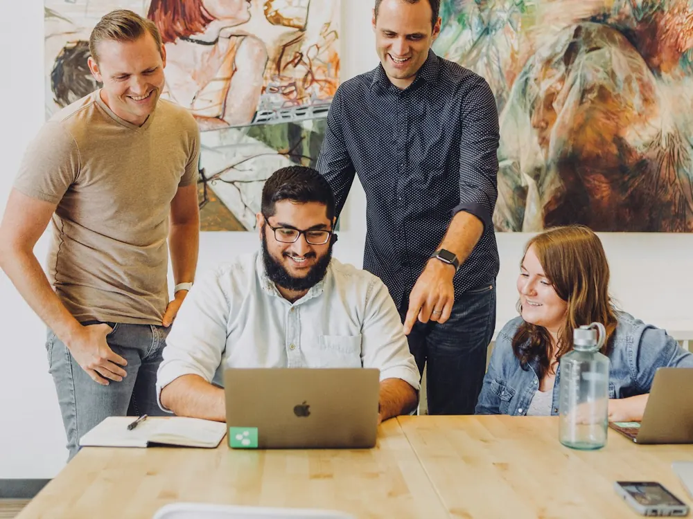 Colleagues working together around a laptop