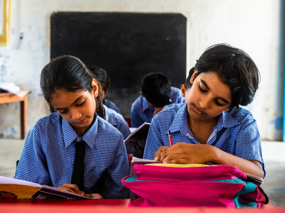 Two girls reading at a classroom desk