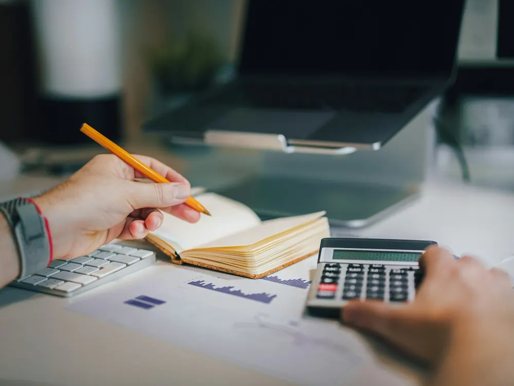 Working out costs with a calculator and notebook