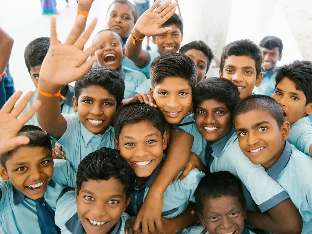 Happy school children waving at the camera