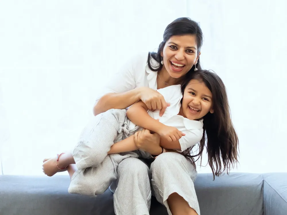 Mother hugging her laughing daughter